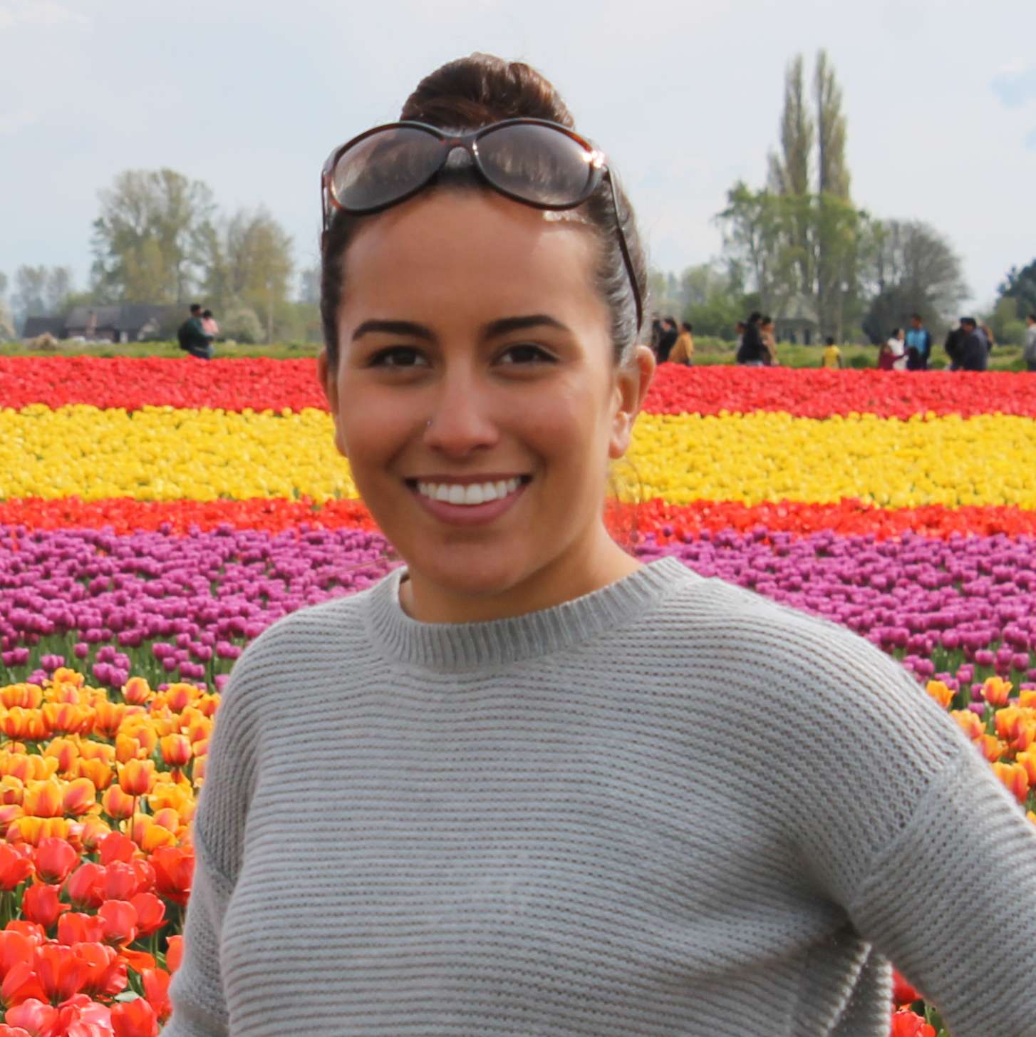 Photo of Alee Zuniga standing in a field of colorful tulips.