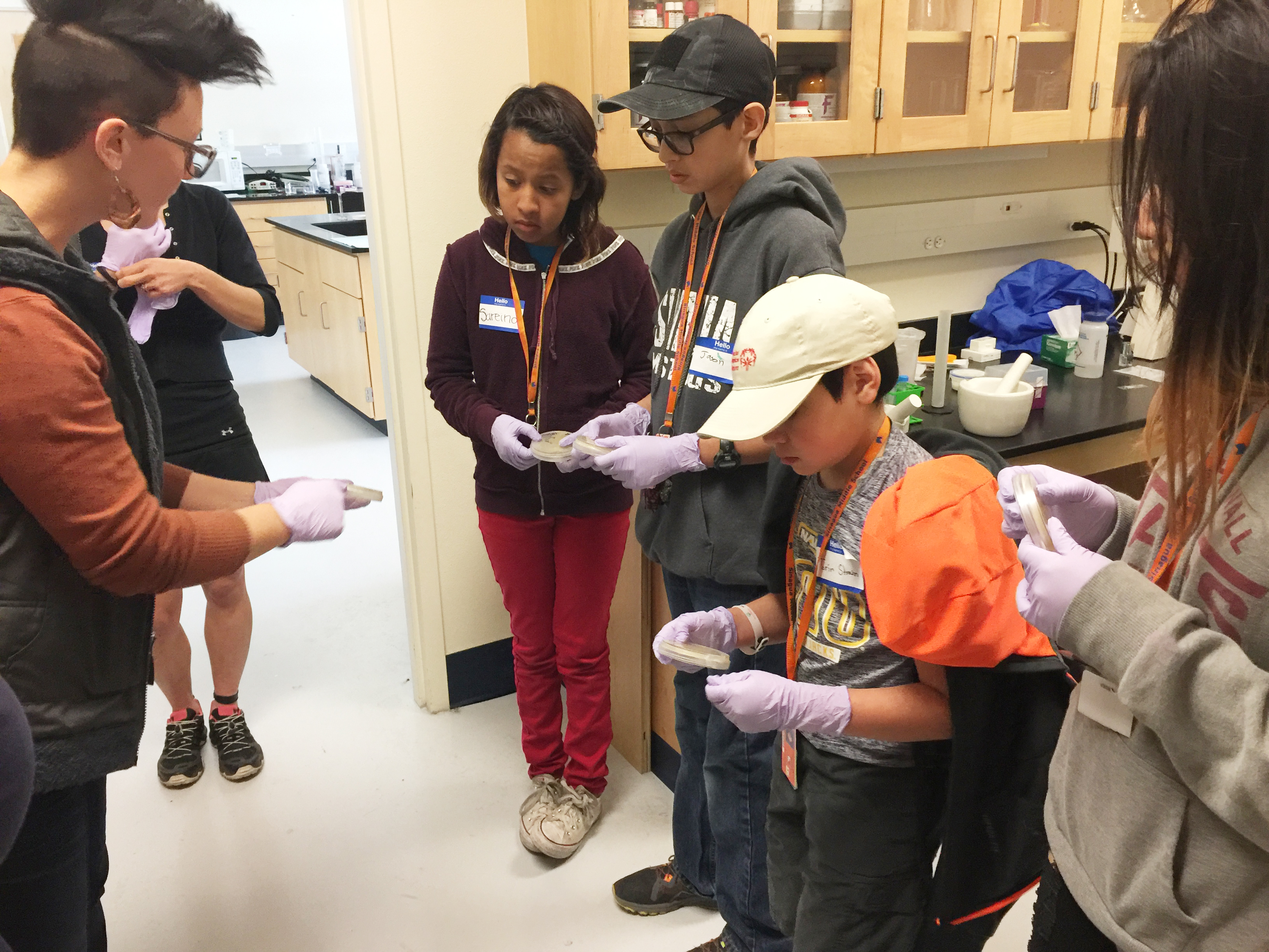 Students in lab gloves working with Ecoss scientists in a university laboratory