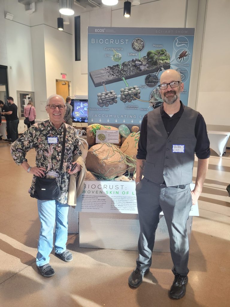 Matt beside the biocrust display, with a guest
