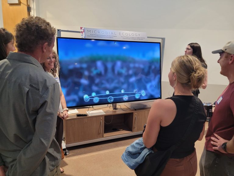 Guests watching a lab diorama on a big screen